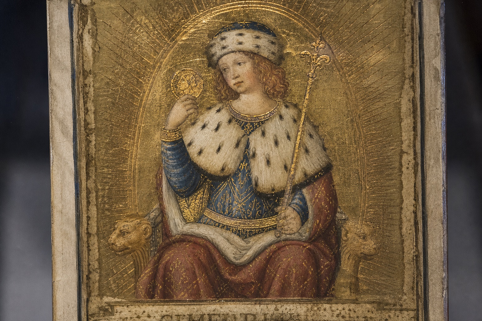 Gilded Renaissance tarocchi card in the Visconti-Sforza style, gold leaf on parchment with a sunburst pattern